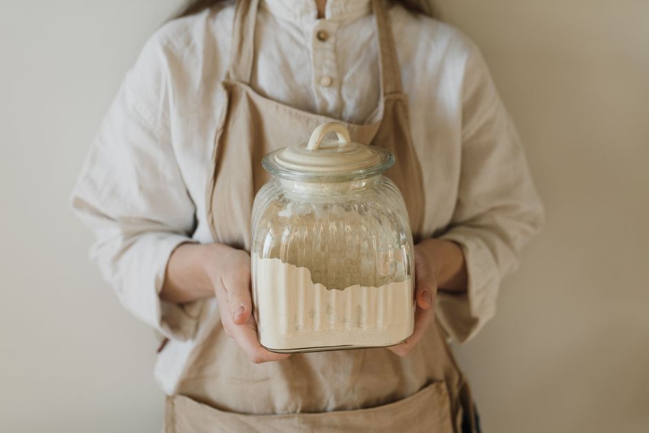 Glas mit frisch angesetztem Sauerteig aus Mehl und Wasser