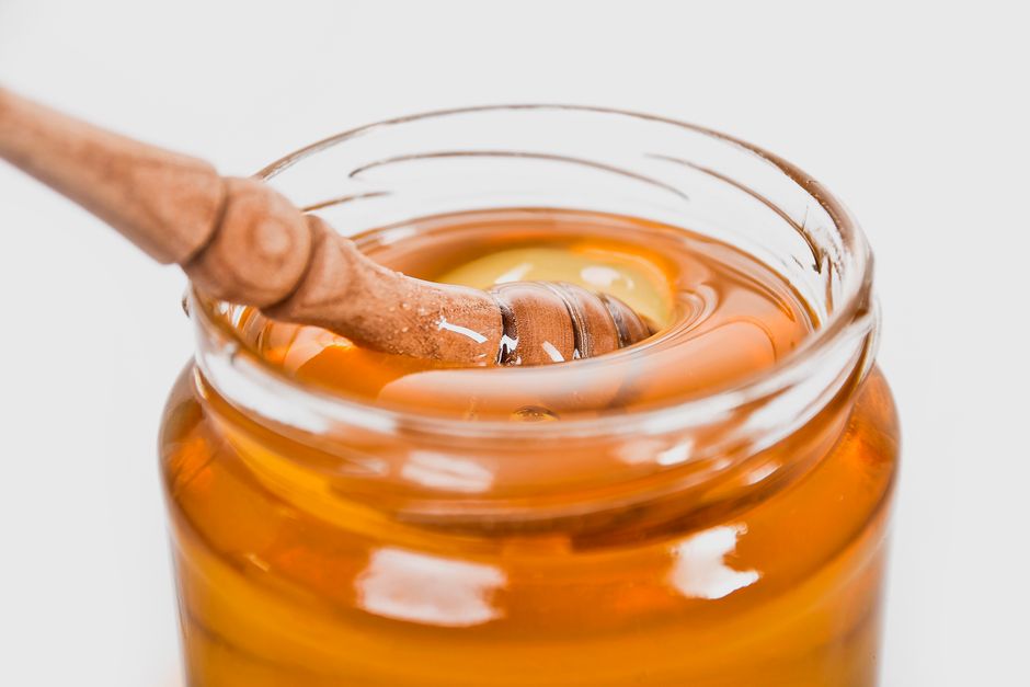 Honig in einem Glas mit Holzlöffel
